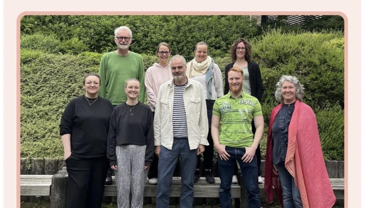 Trainer:innen und Teilnehmende des Kurses Train the Trainer empCARE stehen zusammen im Hof der Caritas-Akademie Köln-Hohenlind