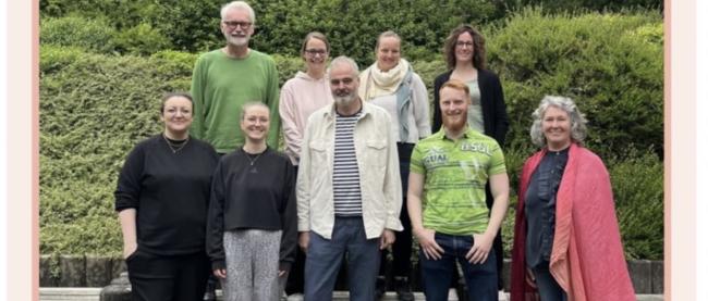 Trainer:innen und Teilnehmende des Kurses Train the Trainer empCARE stehen zusammen im Hof der Caritas-Akademie Köln-Hohenlind