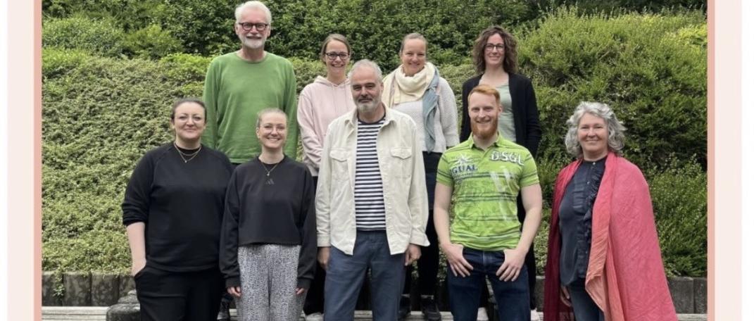 Trainer:innen und Teilnehmende des Kurses Train the Trainer empCARE stehen zusammen im Hof der Caritas-Akademie Köln-Hohenlind